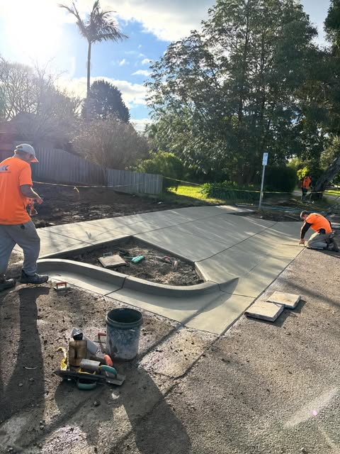 Team finishing a new concrete driveway pour
